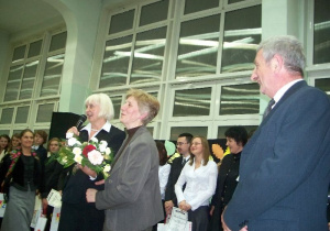 Dyrektor szkoły Jolanta Swiryd wręcza kwiaty pani Janinie Tischer w obecności męża Kazimierza Tischnera